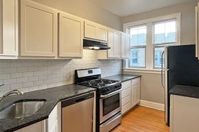 Oak Park apartment for rent - A kitchen with black countertops and white cabinets.
