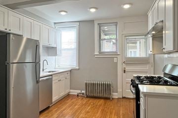 Oak Park apartment for rent - A kitchen with a stainless steel refrigerator and a black stove top oven.