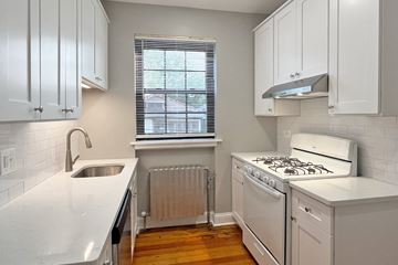 Oak Park apartment for rent - A kitchen with white cabinets and a stove top oven.