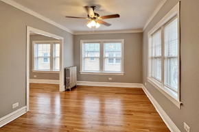 Oak Park apartment for rent - A room with a ceiling fan and wooden floors.