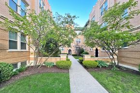 Oak Park apartment for rent - A pathway leads through a landscaped courtyard between two red brick apartment buildings.