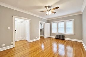 Oak Park apartment for rent - A room with a ceiling fan and wooden floors.