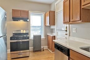 Oak Park apartment for rent - A kitchen with a stainless steel refrigerator and a stove top oven.