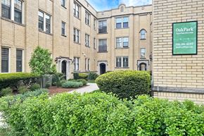 Oak Park apartment for rent - A building with a green hedge in front of it and a sign that says Oak Park.