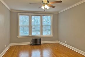 Oak Park apartment for rent - A room with a ceiling fan and a radiator.