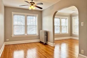 Forest Park apartment for rent - A room with a ceiling fan and a radiator on the floor.