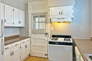 Forest Park apartment for rent - A kitchen with white cabinets and a black stove top.