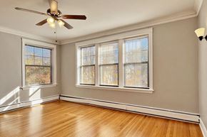 Oak Park apartment for rent - an empty living room with a ceiling fan and windows