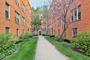 Oak Park apartment for rent - A long concrete walkway leads to a building entrance.