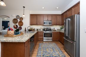 Costa Mesa apartment for rent - A kitchen with wooden cabinets and a granite counter top.