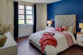 Medford apartment for rent - a bedroom with a bed and a blue wall and a window