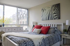 Montreal apartment for rent - a bedroom with a bed with red pillows and a blue and white bedspread
