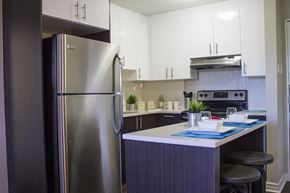 Montreal apartment for rent - a modern kitchen with stainless steel appliances and white cabinets