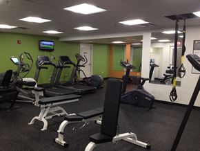 Quincy apartment for rent - a gym with various exercise equipment and a tv