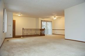 East Lansing townhouse for rent - the spacious living room of an empty house with a railing in the corner