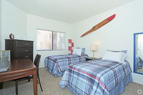 Las Vegas apartment for rent - a bedroom with two beds and a desk with a surfboard on the wall