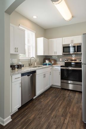 Chapel Hill apartment for rent - a kitchen with white cabinets and stainless steel appliances