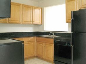 Groton apartment for rent - a kitchen with black appliances and wooden cabinets