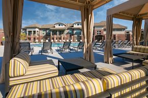 Lincoln apartment for rent - a pool with lounge chairs and tables in front of a building