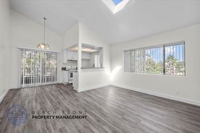 Long Beach apartment for rent - an empty living room with a kitchen and a large window