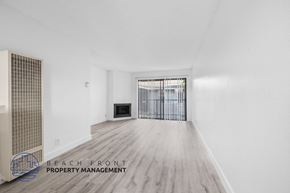 Long Beach apartment for rent - A spacious room with a fireplace and a doorway leading to another room.