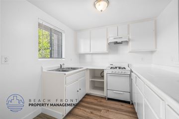 Long Beach apartment for rent - a white kitchen with white cabinets and white appliances and a window