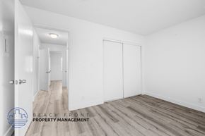 Long Beach apartment for rent - a bedroom with white walls and wood flooring and white closets