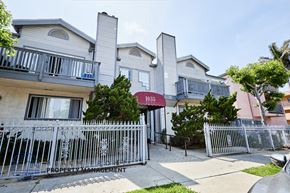 Long Beach apartment for rent - A building with the number 1035 on it is surrounded by a metal fence.