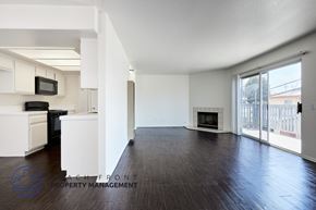 Long Beach apartment for rent - A spacious living room with a fireplace and sliding glass doors.