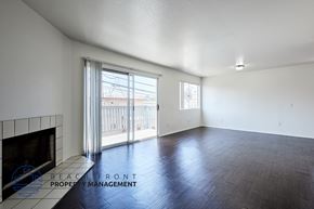 Long Beach apartment for rent - A spacious room with a fireplace and sliding glass doors leading to a balcony.