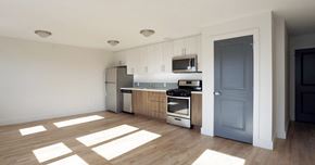 Atlantic City apartment for rent - Open layout living room and kitchen with hardwood floors, stainless steel appliances, wooden and white cabinets