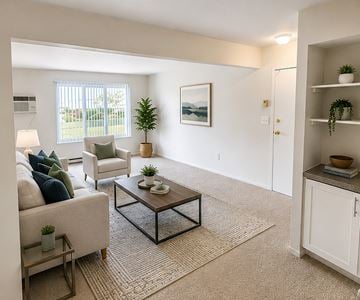 Madison Heights apartment for rent - A living room with a white couch, a coffee table, and a painting on the wall.