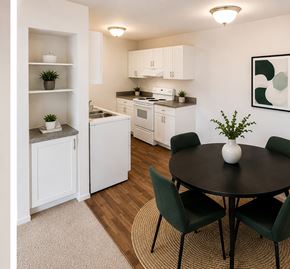 Madison Heights apartment for rent - A kitchen with a table and chairs in the foreground and a sink and cabinets in the background.