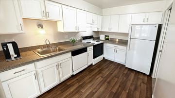 Southfield apartment for rent - A kitchen with white cabinets and a black fridge.