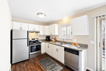 Troy apartment for rent - A modern kitchen with white cabinets and stainless steel appliances.