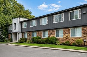 Berkley apartment for rent - A building with a grey and brown facade has a white door and windows.