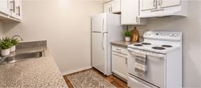 Southfield apartment for rent - A white kitchen with a stove, refrigerator, and sink.