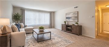 Southfield apartment for rent - A living room with a couch, a coffee table, and a painting on the wall.