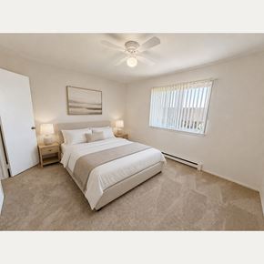Farmington Hills apartment for rent - A bedroom with a large bed and a ceiling fan.