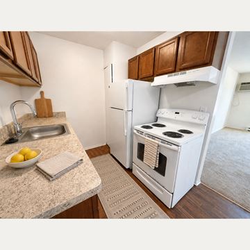 Farmington Hills apartment for rent - A kitchen with a white refrigerator and stove.