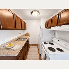 Farmington Hills apartment for rent - A kitchen with a white stove and brown cabinets.
