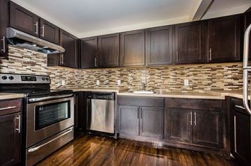 Newark apartment for rent - a kitchen with dark wood cabinets and stainless steel appliances