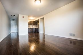 Newark apartment for rent - Living room with partially open layout, darker hardwood floors and white walls
