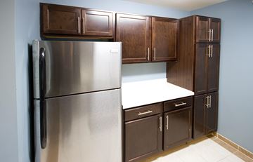 Orange apartment for rent - a kitchen with a stainless steel refrigerator and wooden cabinets
