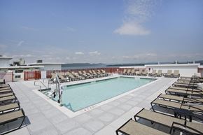 Ossining apartment for rent - a swimming pool on the roof of a building with lounge chairs