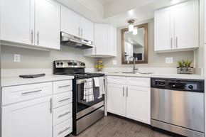 Lansing apartment for rent - a white kitchen with stainless steel appliances and white cabinets