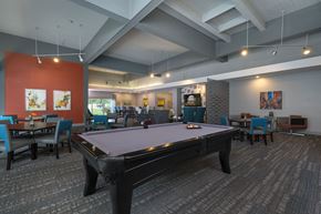 Lansing apartment for rent - a pool table in a room with tables and chairs