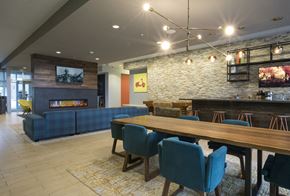 St. Louis Park apartment for rent - A modern dining room with a stone wall and a fireplace.