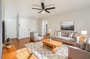 Denver apartment for rent - A living room with a grey couch, a coffee table, and a ceiling fan.