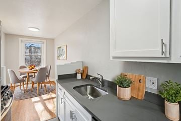Denver apartment for rent - A kitchen with a table and chairs in front of a window.